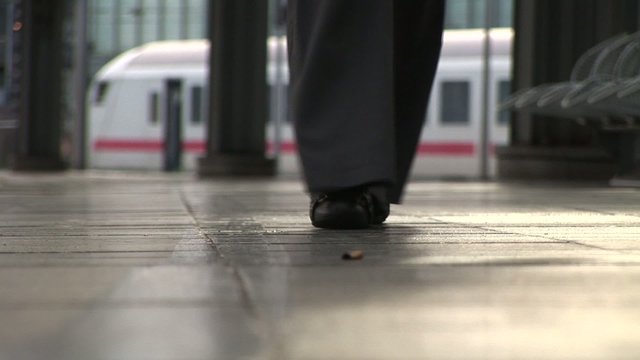 Female foots on Platform. Train on background.