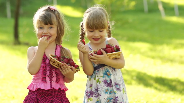 Funny children girl eating strawberries