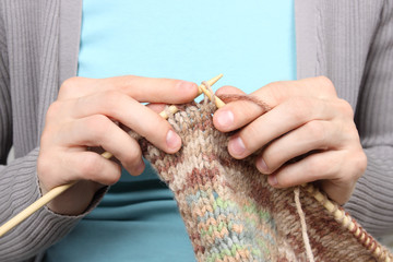 woman knitting brown threads closeup