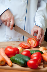 Preparing food: chef cutting tomato