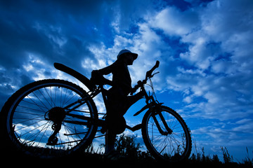 Fototapeta na wymiar cyclist silhouette on a blue sky