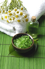 Obraz na płótnie Canvas flowers on towel and Green bath salt in bowl with on green mat