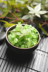 herbal green salt in bowl with branch ivy on mat