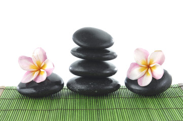Fototapeta na wymiar Balanced Zen stones withl frangipani on green mat