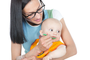 young mother feeding her baby with a spoon
