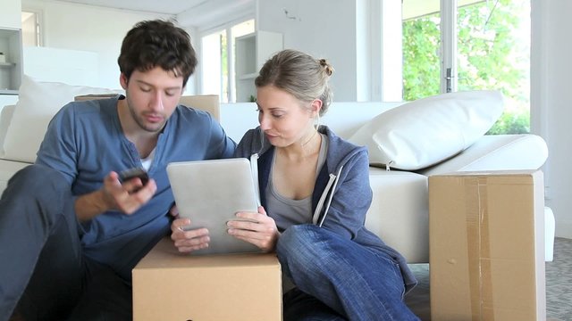Young couple using tablet to find transport company