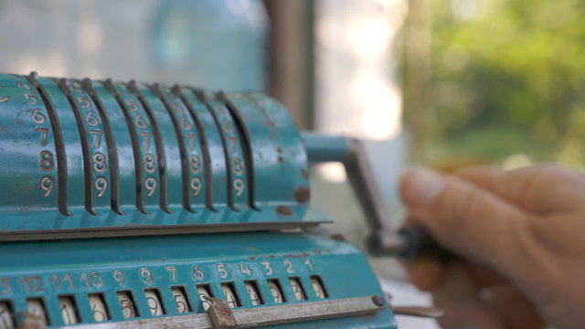 Person using vintage mechanical calculator