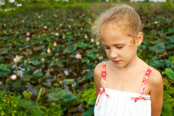 sad girl near pond with lotus