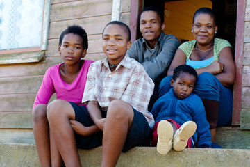 Family on the porch in front of their home. - obrazy, fototapety, plakaty