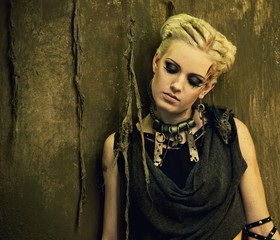 Blond girl against grunge wall