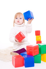 Baby girl plays with toy blocks