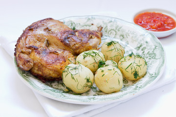 roasted chicken and potato with vegetables on a white plate