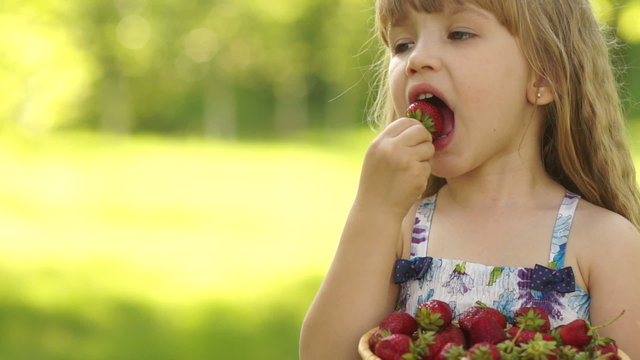 Portrait of a smiling child eating strawberries