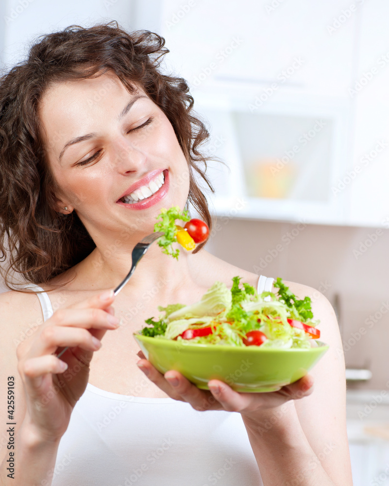 Wall mural diet. beautiful young woman eating vegetable salad