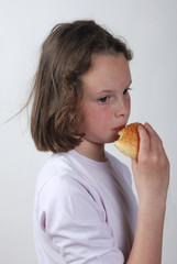 A  young girl eating a bun