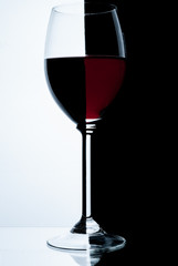 Glass of red wine on a white and black background.