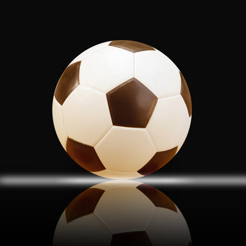 leather soccer ball reflection on black background