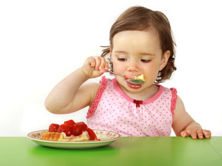 Mädchen isst ein Stück Erdbeerkuchen