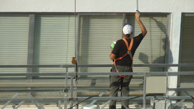 Construction worker on scaffolding repairing the building
