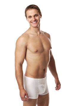 Handsome young man in underwear against white background