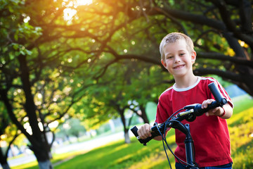 funny  boy rides a bicycle in the park