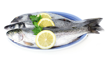 Fresh fishes with lemon and parsley on plate isolated on white