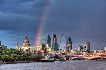 Naklejka premium Panoramę londyńskiej dzielnicy finansowej nad Tamizą z tęczą