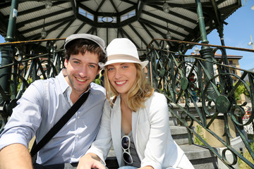 Romantic couple sitting by gazebo in touristic area