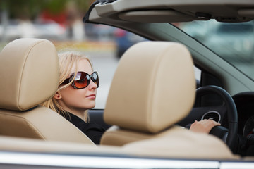 Naklejka premium Young woman driving a convertible car