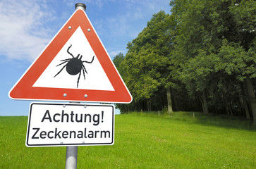 Schild Achtung! Zeckenalarm vor Wald und Wiese