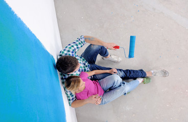 happy young cople relaxing after painting in new home