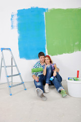 Naklejka premium happy young cople relaxing after painting in new home