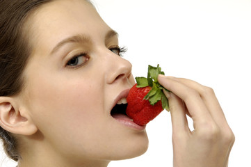 a beautiful girl eating a strawberry