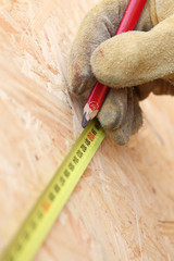Carpenter marking plank of wood