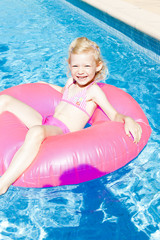 little girl with rubber ring in swimming pool