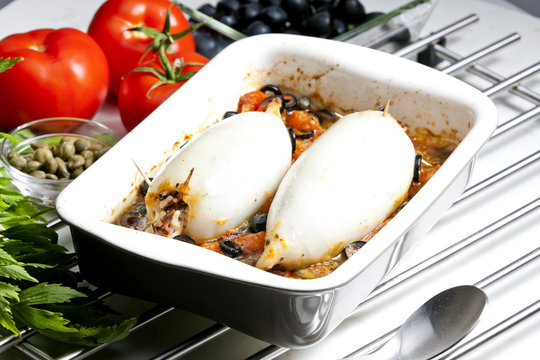 baked sepia with tomatoes and black olives filled with pearl bar