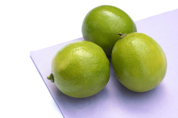 tre lime su tovagliolo viola_sfondo bianco