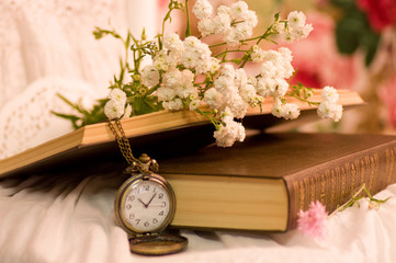 Antique pocket watch,opened old books and flowers