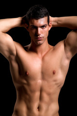 Fototapeta premium Healthy muscular young man. Isolated on black background.