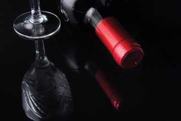 bottle of wine and a glass on a black background