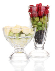 Mixed fruits and berries in glasses isolated on white