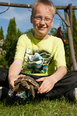 Blonderjunge mit Schildkröte