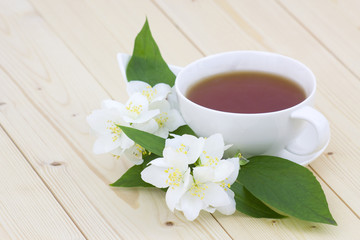 Fototapeta na wymiar Cup of jasmine tea and jasmine flowers
