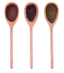 Pepper, black pepper, dried dill in three wooden spoons
