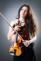 Fototapeta premium Female violin player against background