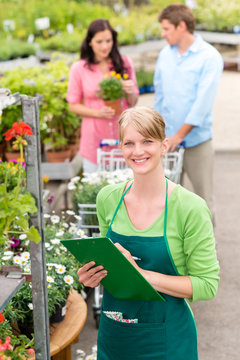 Smiling florist woman at garden centre inventory