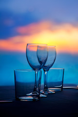 Dish of cups and crystal glasses on sea sunset