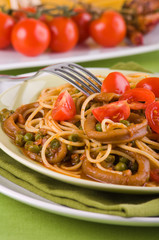 Spaghetti with squids, peas and cherry tomatoes.