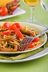Spaghetti with squids, peas and cherry tomatoes.