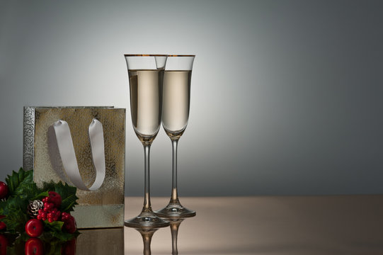 Two champagne glasses on a golden surface